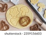 Preparation of festive cookies for baking in the oven. Ready-to-bake cookies in the shape of autumn leaves and pumpkins.