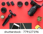 Flatlay of Mirrorless Camera, Lenses, Cleaning set And Accessories on red background as top view of Creative Gear for photographer, traveller and blogger