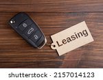 Car Leasing concept. Rent or buy? Vehicle security key with tag on the wooden background