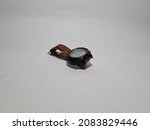 Black watch with brown strap on white background