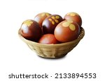 Easter basket with naturally dyed eggs with onion skins isolated on white background                                    