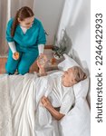 Small photo of Nurse brought pills to elderly woman at her home. Solicitous professional medical female staff caring in a geriatric institution with a senior patient. Lifestyle nursing service.