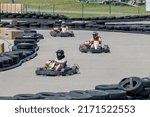 Small photo of Saint-Zotique, Canada - June 25, 2022: Go kart riders race around an outdoor track and jockey for position