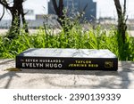Small photo of Setif, Algeria - November 18, 2023: Close-up Taylor Jenkins Reid's The Seven Husbands of Evelyn Hugo novel in the garden.