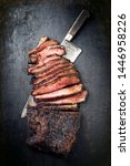 Small photo of Traditional smoked barbecue wagyu beef brisket offered as top view with knife on an old rustic board with copy space