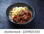 Traditional Hungarian braised venison goulash with vegetable and spaetzle in spicy sauce served as close-up in a Nordic design bowl 