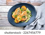 Small photo of Modern style traditional Italian deep-fried chicken piccata with capper and pasta offered as top view in a design plate with copy space