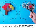 Small photo of Human brain is made gear mechanism and colourful shapes on blue background. The brain is viewed through a magnifying glass. Brain disturbance concept, brain disorder. Different thinking.