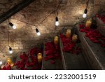 Decorated staircase in the loft for the event. The steps are strewn with rose petals and candles, a garland of light bulbs on the wall.