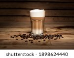 glass of latte macchiato coffee on brown background