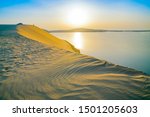 Desert at sunrise, morning glow over dunes and inland sea of the Sealine Desert just out of Doha, Qatar.