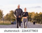 Two Positive Runners as Couple Training Together During Running Training Fitness Exercise At Nature Outside as Runners During Training Outdoor Process. Horizontal Image