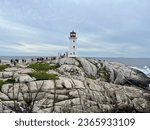Small photo of Peggy's Cove, NS, CAN, 8.15.23 - Tourists climbing on the rocks around Peggy's Cove lighthouse.