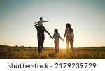 Small photo of Happy family walk in field in nature.Parents and children are free and active people in nature.Healthy and cheerful family at picnic in the park.Summer walk in the park at sunset.Parents and children