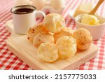 Small photo of Minas Gerais cheese bread, hot, with a cup of black coffee and butter, on a checkered picnic tablecloth, close up photo