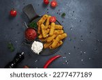 Small photo of Cooked Mozzarella Cheese sticks with tartar and red tomato sauces on a plate