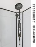 Small photo of Shower faucets attached to tiled wall near sink with mirror and glass partition and ornamental curtail in washroom at home