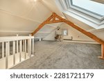 an attic loft with skylights and carpeted flooring in the attic, which has been used as a home office