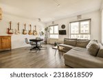 Small photo of a living room with guitars hanging on the wall and an office chair in the fore - image taken from above