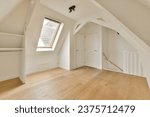 an empty room with wood flooring and skylights on the top of the attic loft windows are visible in the photo