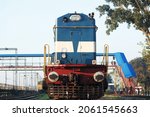 Indian Railways Diesel Locomotive of type WDM3A accelerating hard and passes through a curved track after a scheduled halt at a suburb station.Close front engine view of Indian train running on track.
