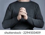 Small photo of Hands in prayer gesture with interlaced fingers. Sign of entreaty, reconciliation.