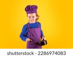 Small photo of Kid chef cook with cooking pot stockpot. Child wearing cooker uniform and chef hat preparing food on kitchen, studio portrait. Cooking, culinary and kids food concept.