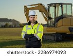 Small photo of Caucasian man, construction worker in helmet at construction site. Industry engineer worker in hardhat near bulldozer or digger tractor. Concept of construction industry. Construction site manager.