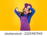 Small photo of Kid chef cook with cooking pot stockpot. Cooking children. Chef kid boy making healthy food. Portrait of little child in chef hat isolated on studio background. Kid chef. Cooking process.