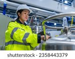 Small photo of Asian engineer working at Operating hall,Thailand people wear helmet work,He worked with diligence and patience,she checked the valve regulator at the hydrogen tank.