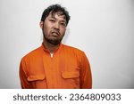 Small photo of Prisoner in orange robe concept,Portrait of asian handsome man in Prison uniforms,Bandit has a lot of muscle