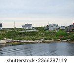 Small photo of Peggy's Cove, NS, CAN, August 15, 2023 - A view of the houses on a hill along the water at Peggy's Cove, Nova Scotia.