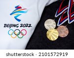 Small photo of BEIJING, CHINA, JANUARY 1, 2022: Gold, silver and bronze, medal set on snow, original wallpaper for winter olympic game in Beijing 2022. Black board.