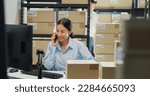 Small photo of Happy Asian girl and man partner wear formal shirt sit in front desk computer pick up phone purchase order stock detail customer online data delivery at warehouse. Startup small business concept.
