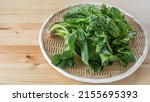 Small photo of Spinach on a bamboo basket. Japanese shrunken spinach.