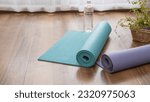 A rolled up yoga mat and water. ...