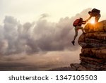 People helping each other hike up a mountain at sunrise. Giving a helping hand, and active fit lifestyle concept.Asia couple hiking help each other.