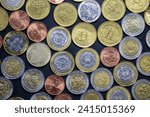 Small photo of Argentine coins of different values on a dark background. In disuse due to uncontrolled monetary emission. Inflation.