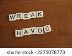 Small photo of A message spelled out with letter tiles. Wreak havoc. To cause chaos or great damage.