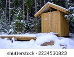 Traditional wooden country toilet in winter in Latvia.