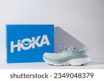 Small photo of Strasbourg, France - August 2023 : Hoka Bondi 8 new green running shoes and shoe box side view. Stylish monochrome shoes for active people that incorporate new health technology