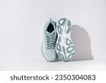 Small photo of Strasbourg, France - August 2023 : Hoka Bondi 8 new green running shoes on white background from top and sole. Stylish monochrome shoes for active people that incorporate new health technology