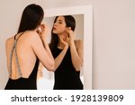 Lady wears beautiful black dress looking into the mirror