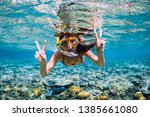 Happy young woman swimming underwater in tropical sea. Snorkeling in Indian ocean