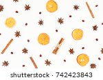 Pattern of cinnamon, anise and dried oranges isolated on white background. Flat lay, top view. Christmas or New Year concept