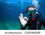 Underwater shoot of a man diving with scuba and showing ok signal