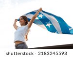 Small photo of latina girl from guayaquil smiles as she holds the city's flag in honor of the independence celebrations on october 9th.