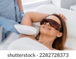 Laser hair removal procedure in a cosmetology beauty salon. Woman cosmetologist removes body hair. Professional aesthetic skin care in a beauty clinic. Smooth and soft skin hands and feet without hair
