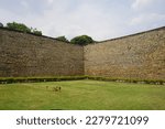 Small photo of A View of Bangalore fort walls along green lawn. Bangalore Fort began in 1537 as a mud fort. The builder was Kempe Gowda I, a vassal of the Vijaynagar Empire and the founder of Bangalore.