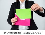Small photo of Elegant Businesswoman Putting Important Memorandum In Envelope For Sending. Woman Wearing Suit Holding Business Letter In Hands Sending Crucial Message Through Post.
